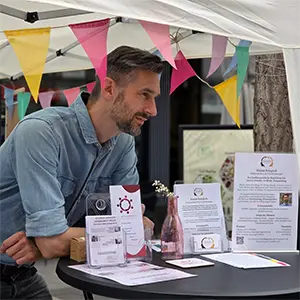 Foto vom Boulevard Gevelsberg 2026 am Stand der Kette der Solidarität e. V. Zu sehen sind Florian Kriegisch sowie Flyer, Visitenkarten und ein Aufsteller von Mentales Gleichgewicht. Die Veranstaltung bot Gelegenheit für persönliche Gespräche und Austausch vor Ort in Gevelsberg.